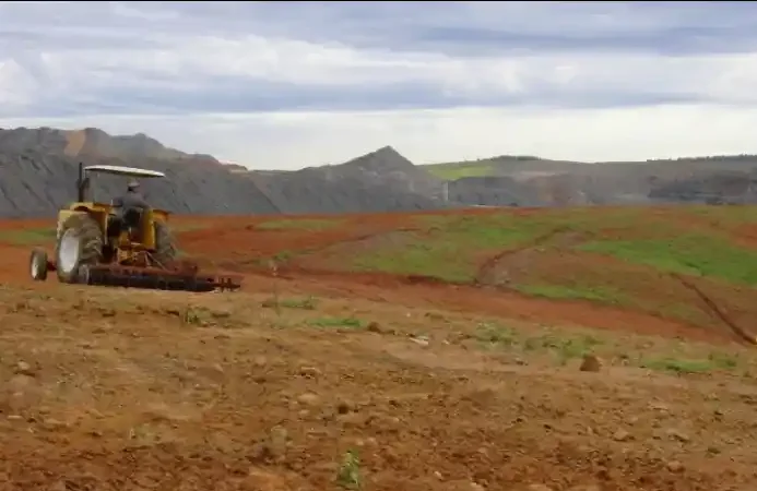Traktor melakukan pengolahan tanah di lahan bekas tambang sebagai bagian dari teknik perbaikan struktur tanah untuk mendukung reklamasi dan revegetasi.